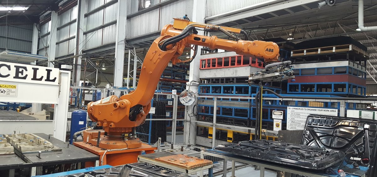 ABB articulated robot handling parts in a guarded cell