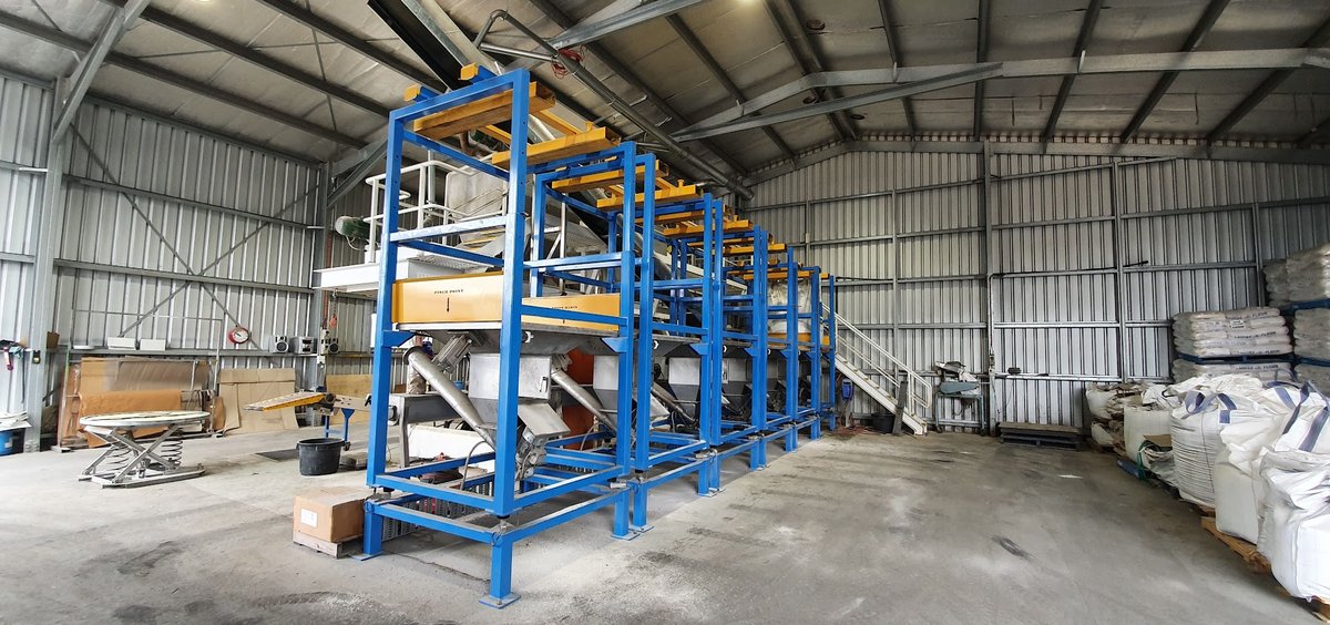 Bulk blending plant at the Beaudesert feed mill - blue steel structural framework, loss-in-weight silos and hoppers
