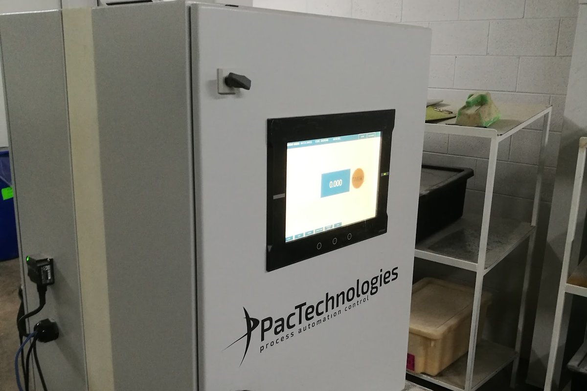 PAC Technologies weighup station cabinet in a micro room at the Beaudesert feed mill, with HMI screen reading 0.000 and a barcode scanner mounted at hand height