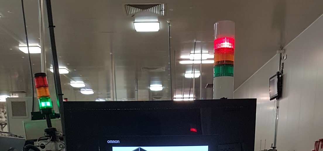 Operator HMI station with signal tower on a food production floor