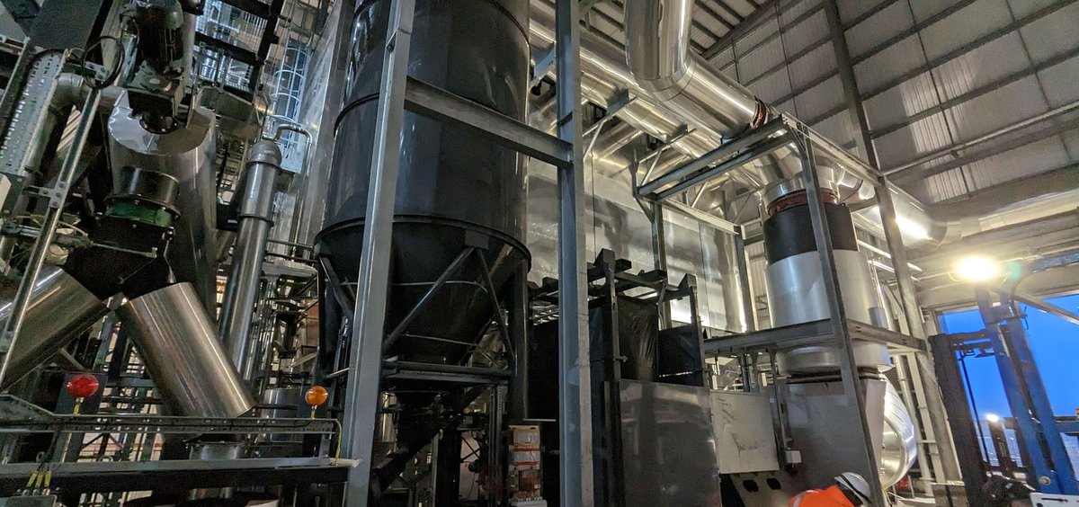 Process plant interior with stainless silos and gantries