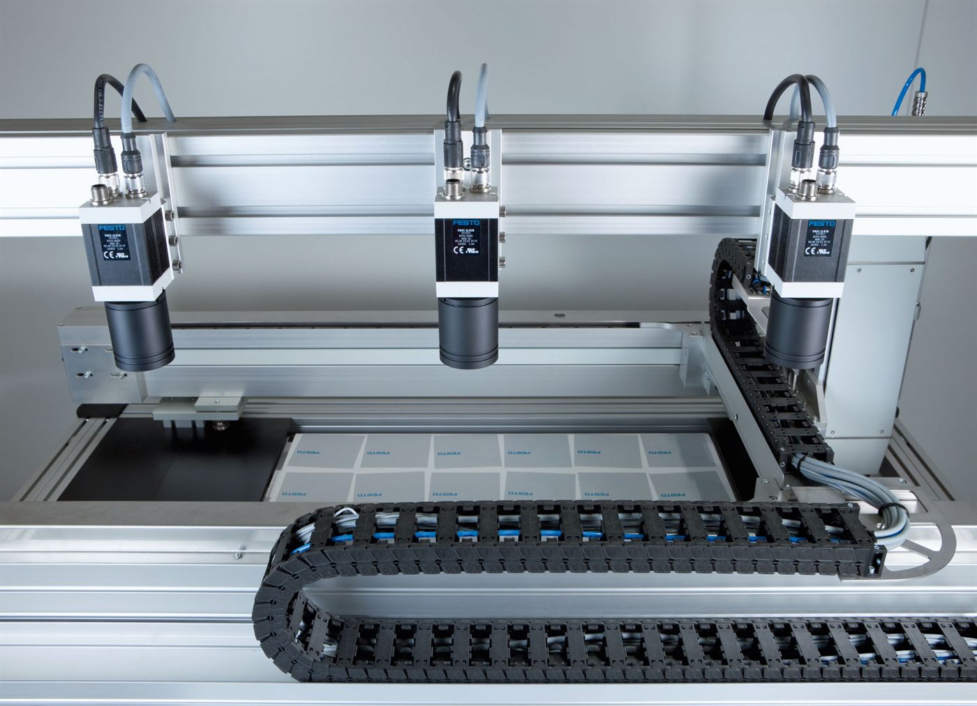 Industrial machine vision cameras on a gantry above an inspection bed